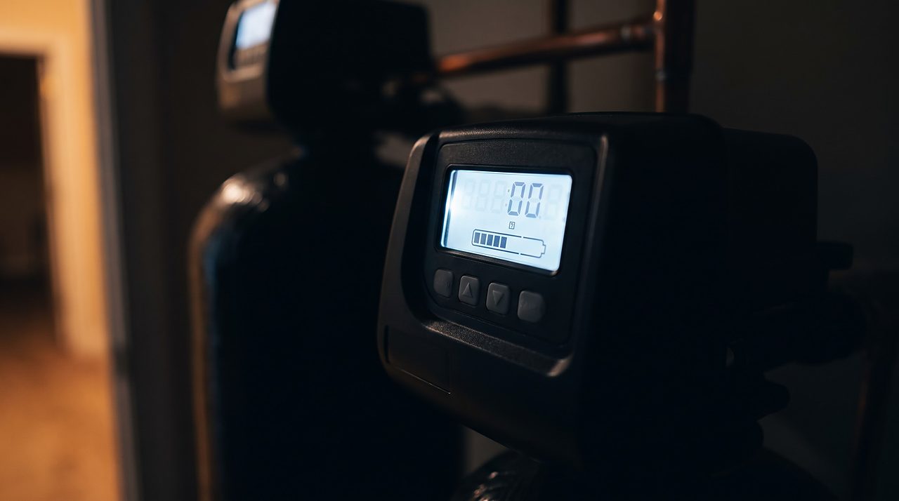 water softener control valve display glowing at night during an unscheduled regeneration cycle