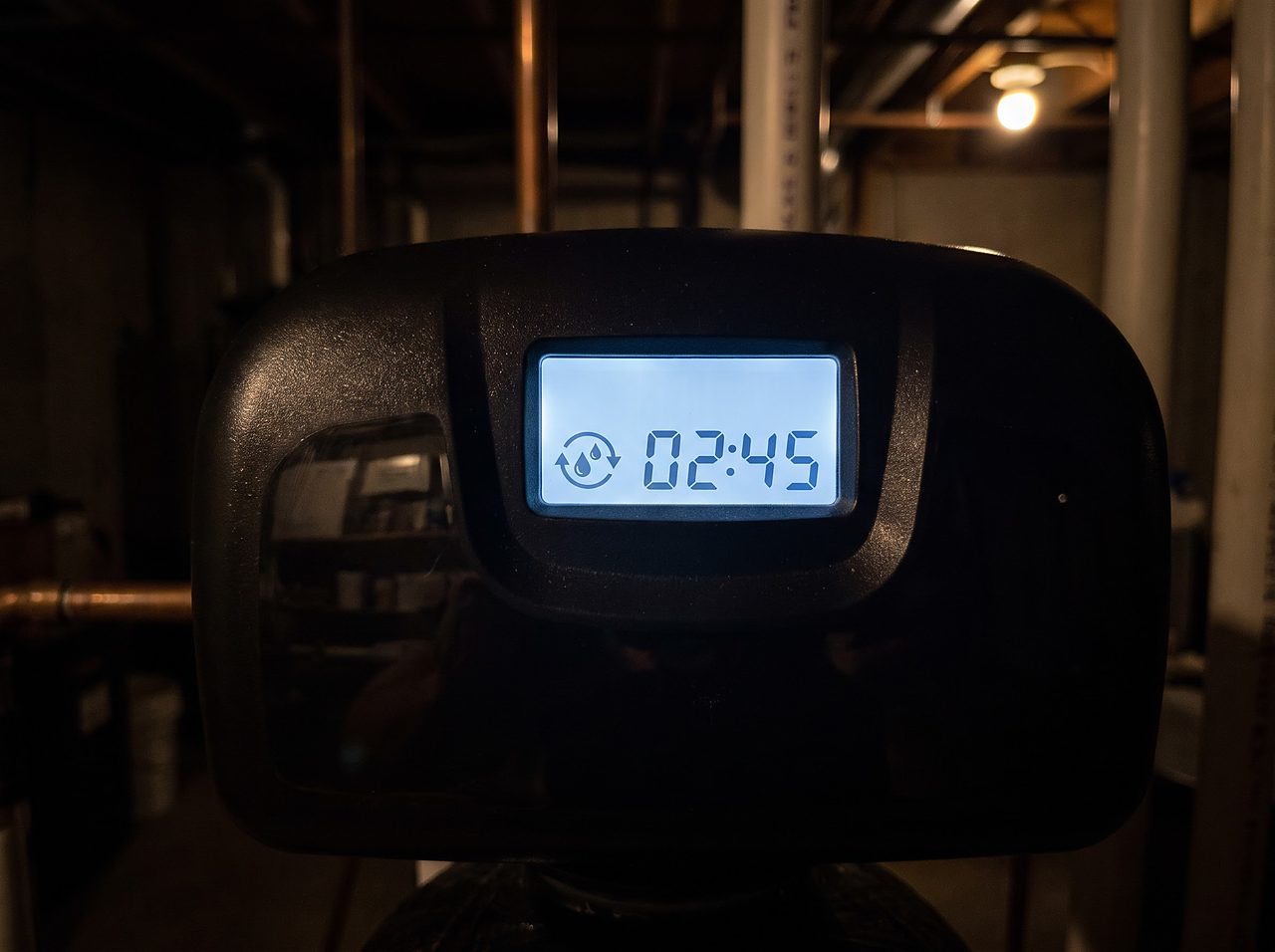 digital control display on a water softener valve glowing during a cycle
