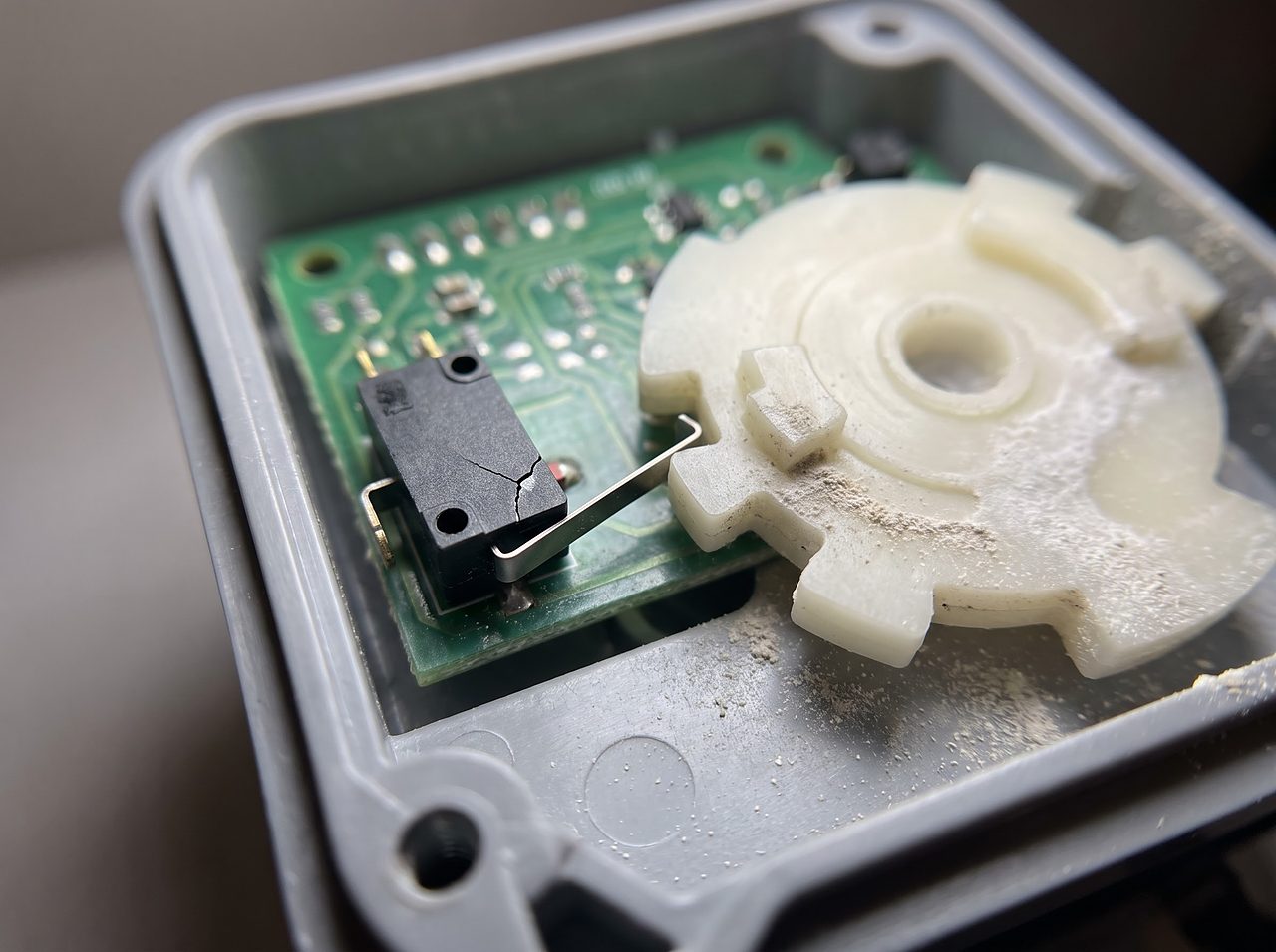 a small position switch resting against a control valve cam wheel inside an open housing