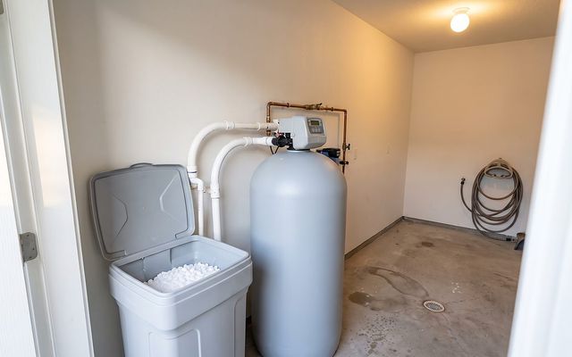 residential water softener resin tank and brine tank in a home utility closet